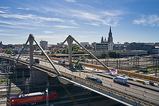 Foto einer Brücke mit Stadt im Hintergrund