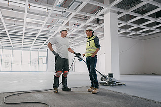 Foto von zwei Personen in einer Halle am reden