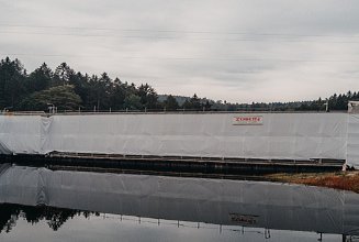 Foto von weißen Schutzplanen am Staudamm
