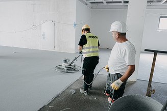 Foto von zwei Personen mit Baustellenausrüstung und Geräten