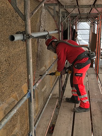 Foto von mehreren Personen in roter Baustellenausrüstung