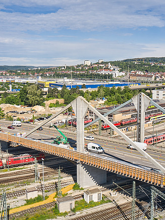 Foto von einer Brücke mit Straßenverkehr und Bahnschienen