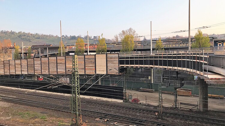 Foto einer Brücke mit Holzgeländern über Schienen