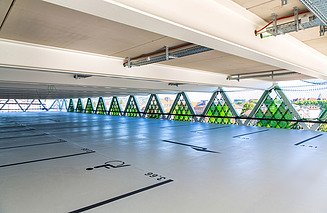 Foto eines Parkdecks mit Parkbuchten und grünen Glaslamellen