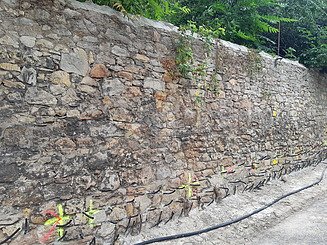 Foto einer alten Mauer mit gelben Markierungen